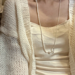 S925 silver pearl knot necklace with a mixed chain design worn over a knit sweater