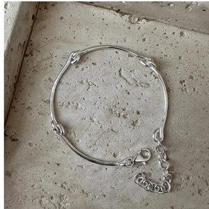 Close-up of S925 silver bracelet featuring minimalist knots and adjustable lobster clasp
