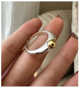 Detail of adjustable S925 silver ring featuring silver band and gold bead accents