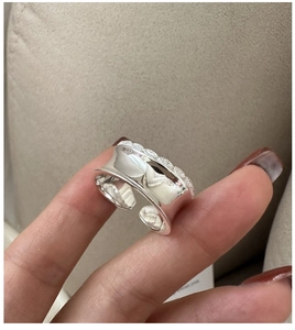 Close-up of S925 sterling silver wide ring with polished surface and wavy diamond edge
