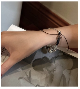 Detail of S925 silver cuff and dark brown woven beaded bracelet set on a wrist
