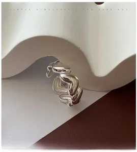 Macro detail of S925 sterling silver heart chain ring on artistic paper background