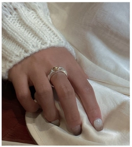 Detail of S925 sterling silver ring with two-tone silver band and gold bead focus