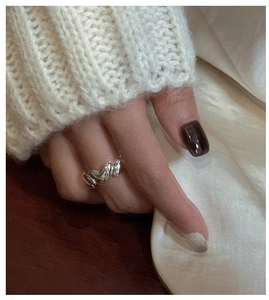 Detailed view of multiple heart-shaped S925 sterling silver rings worn on a hand