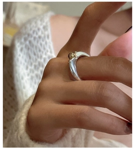Macro detail of minimalist S925 sterling silver ring with two-tone gold ball accent