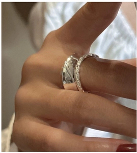 Close-up of stacked S925 sterling silver rings with polished finish and embossed texture
