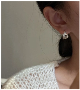 Dettaglio dell'orecchino a spirale in argento S925 indossato su modella per stile
