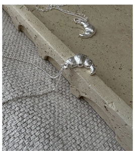 Detailed macro view of S925 sterling silver croissant pendant with textured surface