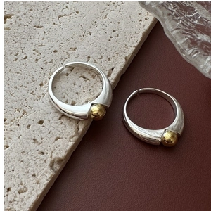 Detailed close-up of two-tone S925 sterling silver adjustable rings on textured stone