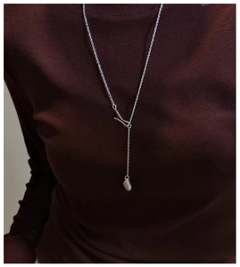 Macro view of matte silver irregular pendant on minimalist S925 long lariat chain