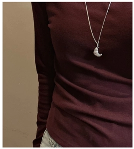 Detail of S925 silver croissant pendant necklace on model with textured finish
