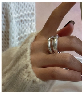 Double-layered matte silver ring shown on finger with beige knit sweater background