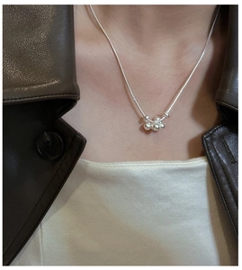 Detail of S925 sterling silver frosted grape cluster pendant necklace on a model