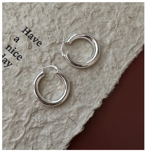 Détail de boucles d'oreilles créoles en argent massif S925 avec poinçon visible