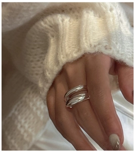 Polished silver double-layered minimalist ring worn over white knit sleeve detail