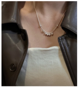 Close-up of minimalist S925 sterling silver beaded necklace worn on a female model