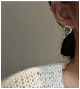 Detail of vintage silver stud earring with grey labradorite worn by a female model