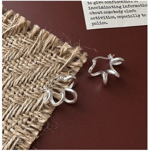 Dettaglio macro di orecchini a cerchio in argento sterling S925 con texture a spirale