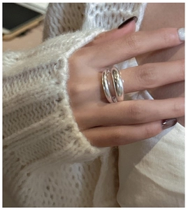 Detail of a minimalist double-layer polished silver ring on hand with a knit sweater