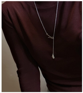 Minimalist S925 silver lariat necklace with irregular pebble pendant on a dark sweater