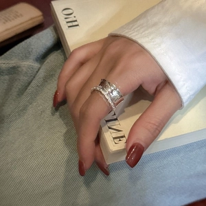 Elegant wide S925 sterling silver ring with textured edges worn by a model in French style