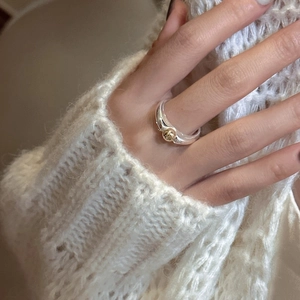 Minimalist S925 sterling silver ring with contrast gold bead on white knit background