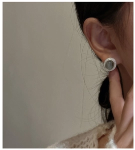 Close-up of vintage S925 sterling silver stud earrings with labradorite stone on model