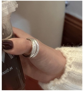 Detail view of a double-layered matte S925 sterling silver ring worn on the thumb