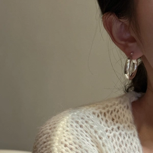 Créoles minimalistes en argent sterling S925 portées par un mannequin avec un style élégant