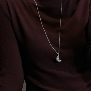 Minimalist S925 sterling silver croissant moon necklace with textured pendant on a model