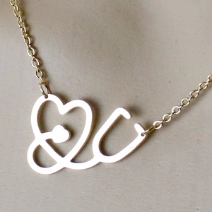 Gedetailleerde close-up van de gouden stethoscoop hart hanger ketting met metaalglans