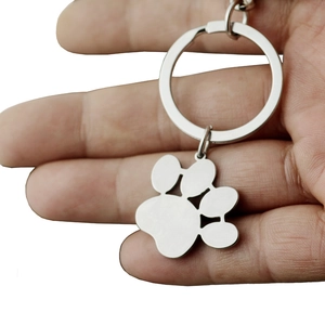 Polished stainless steel pet paw print keychain held in hand for pet lovers