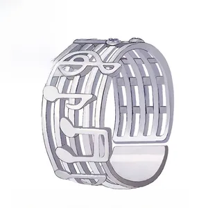 Dettaglio di anello geometrico argento con motivi di note musicali e fascia larga aperta