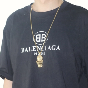 Hip hop style gold basketball hoop pendant necklace worn with a streetwear outfit