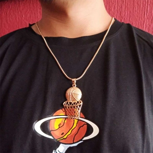 Detail of hip hop gold basketball and hoop pendant necklace worn on a person