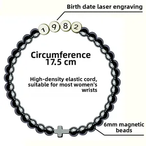 Detail of 6mm black magnetic beads bracelet with 1982 laser engraving and cross charm