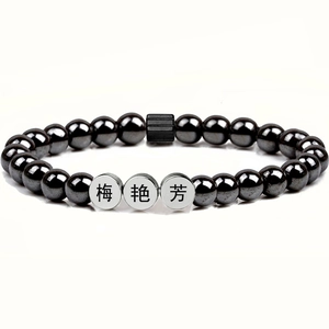 Macro detail of custom engraved hematite beads on a magnetic healing stone bracelet
