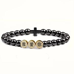 Detailed macro view of black hematite bead bracelet with cross charm and I Love You beads