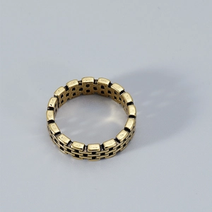 Macro detail of golden brick chain link ring with vintage textured finish and open band