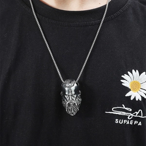 Detailed close-up of a vintage silver Viking pendant necklace worn on a male model