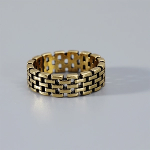 Macro detail of vintage gold brick link ring with textured chain design and rustic finish