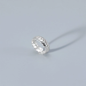 Detailed close-up of a silver wheat grain woven texture on an adjustable open ring