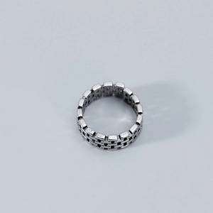 Detail view of silver brick chain ring with vintage texture and industrial grid pattern