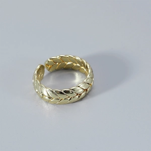 Detailed view of the golden wheat braided texture on the adjustable open metal ring