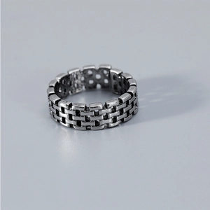 Detailed close-up of a vintage brick-patterned silver ring with an industrial design