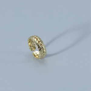 Macro detail of golden wheat-patterned adjustable open ring with woven metal texture