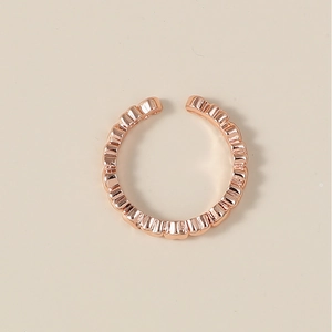 Détail d'une bague réglable en or rose avec relief vertical et bords ondulés
