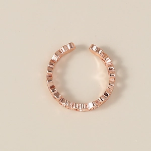 Macro di un anello aperto in oro rosa con motivo a cuori traforati continui e lucidi