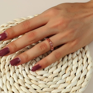 Dettaglio del motivo a cuore scavato su un anello in oro rosa indossato da una modella