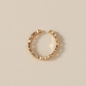 Dettaglio di un anello a cuore regolabile dorato con design ondulato e traforato